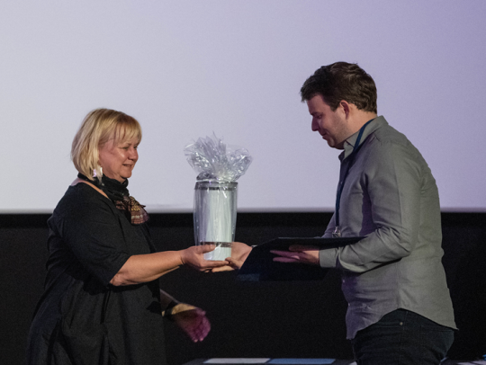 Kolonics Erika az SZRMK ügyvezetője átadja Szeged város díját Szebeni Gábor operatőrnek